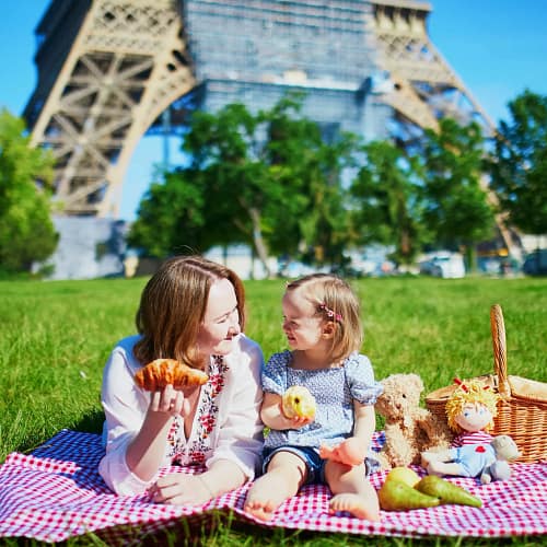 Mother and daughter enjoying a French-style picnic in front of the Eiffel Tower