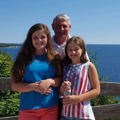father enjoying a beautiful moment outdoors with his two daughters on Father’s Day.