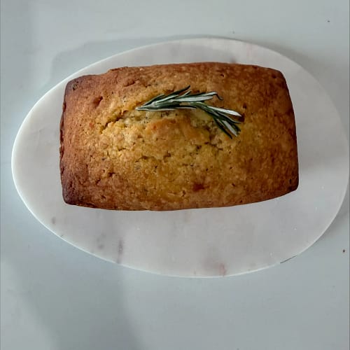 Orange Rosemary Carrot Patch mini loaf cake topped with rosemary, served on a white plate as part of the Base & Bloom recipe collection.