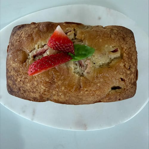 Strawberry Basil Picnic mini loaf cake topped with fresh strawberry slices and basil, served on a white plate for the Base & Bloom guide.