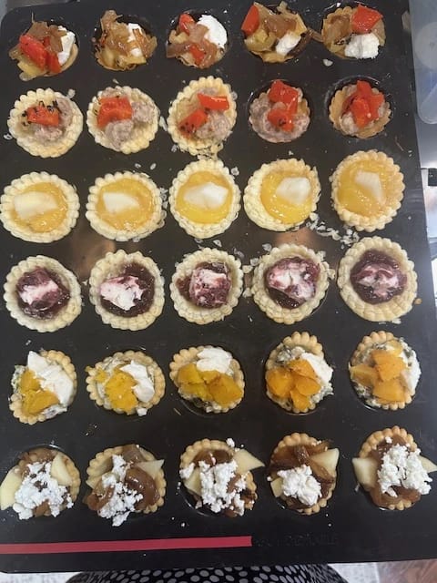 Assorted mini tartlets in a bon COOK Mini Tartlet Tray with sweet and savory fillings, ready to bake.