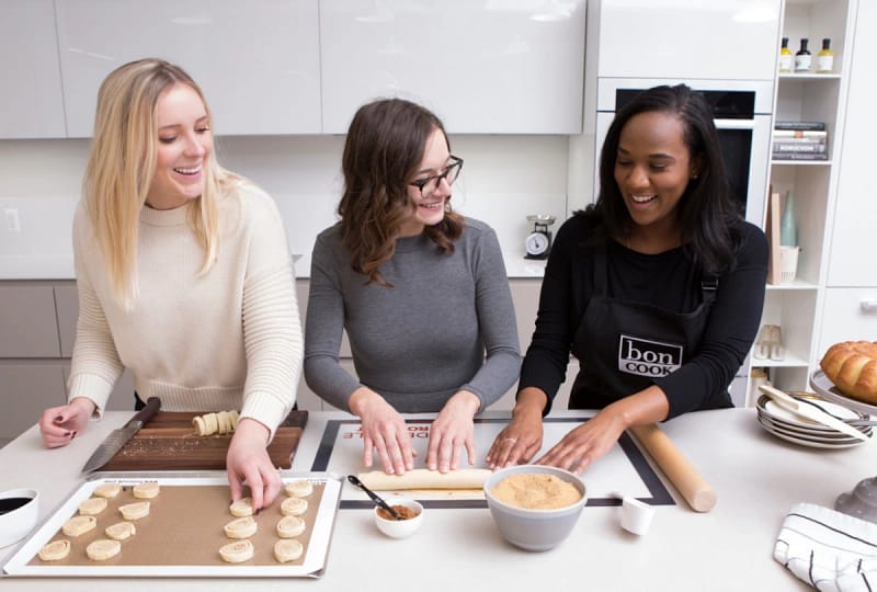 Three women baking together using bon COOK mats and bakeware.