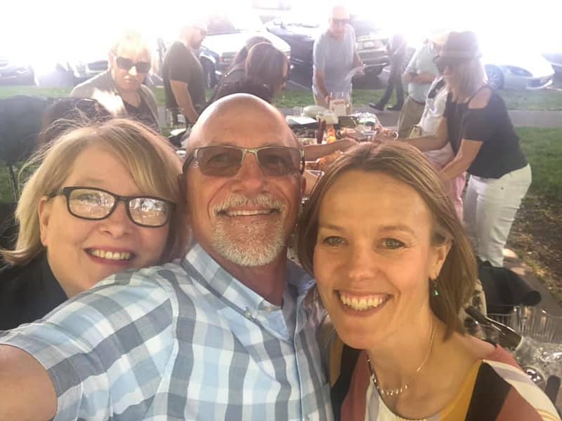 Friends enjoying wine and food at a park picnic, showing how to pack the perfect picnic with local finds.